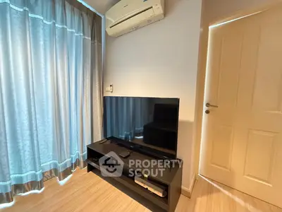 Cozy living room with modern TV setup and air conditioning, perfect for relaxation.