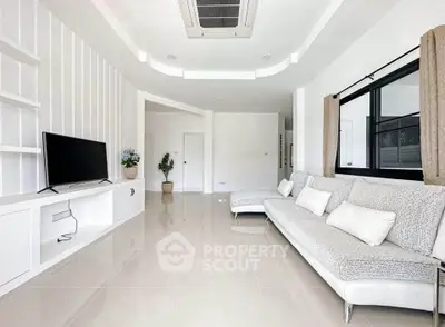 Spacious modern living room with sleek furniture and large window, perfect for relaxation and entertainment.