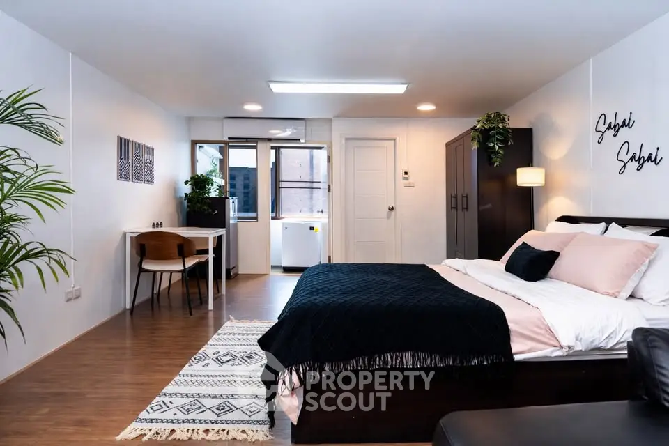Spacious modern bedroom with stylish decor and natural light, perfect for urban living.