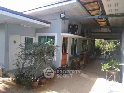 Charming single-story home with spacious outdoor patio and lush greenery.