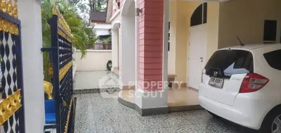 Charming residential entrance with carport and decorative gate