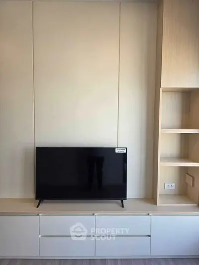 Modern living room with sleek TV unit and built-in shelving, perfect for stylish urban living.
