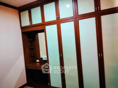 Spacious bedroom with elegant built-in wooden wardrobe and vanity desk