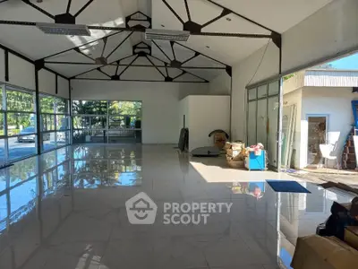 Spacious open-plan interior with high ceilings and large windows, ideal for versatile use.