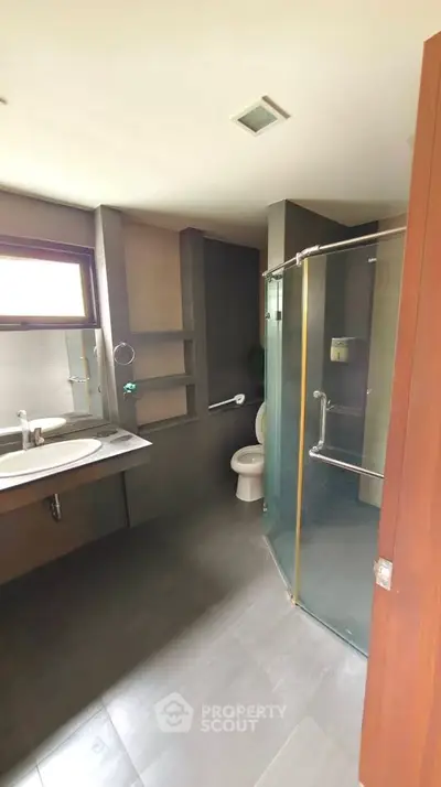 Modern bathroom with glass shower and sleek fixtures in a contemporary home.