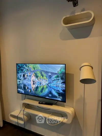 Modern living room with wall-mounted TV and stylish shelves