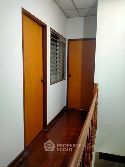 Charming hallway with wooden doors and railing, perfect for cozy home ambiance.