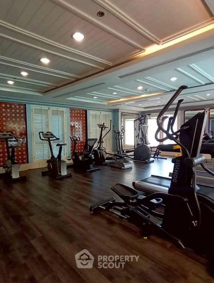Luxurious gym with modern equipment and elegant design in upscale residential building.