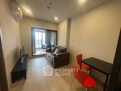Modern living room with balcony view, featuring cozy sofa and dining area.