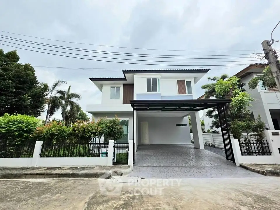 Modern two-story house with spacious driveway and lush greenery in a serene neighborhood.