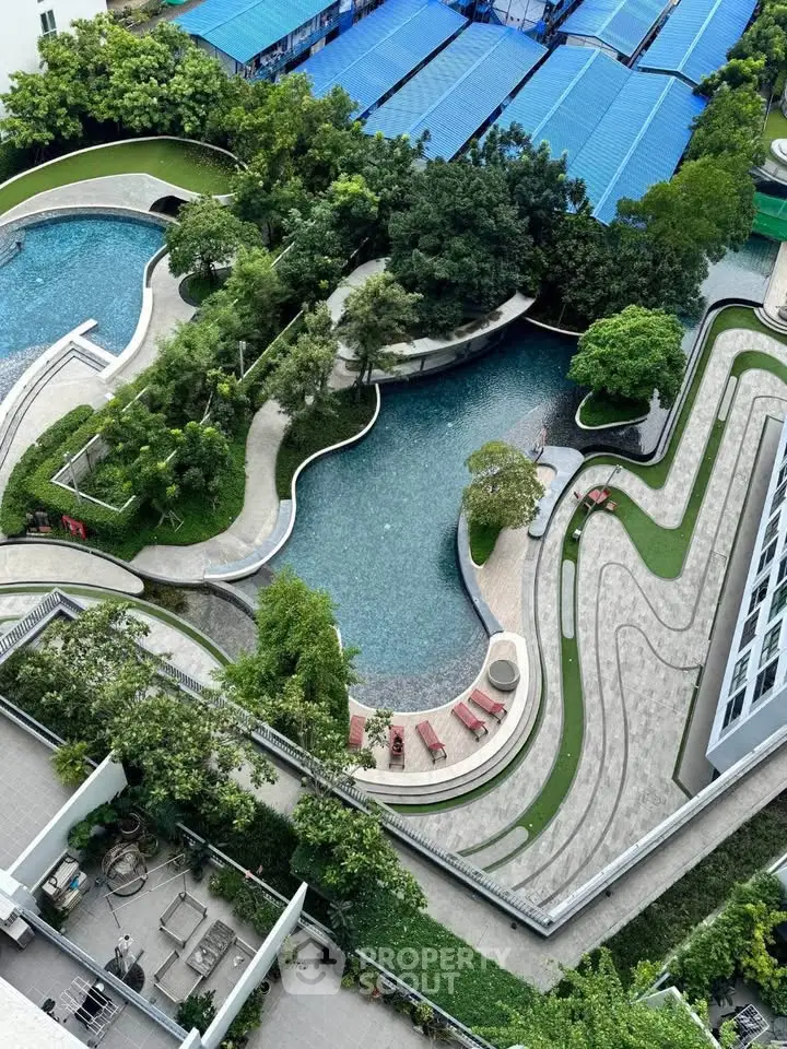 Stunning aerial view of modern residential complex with lush gardens and elegant pool area.