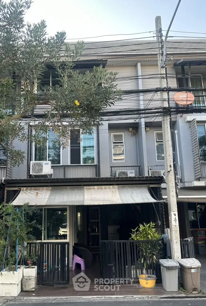 Charming townhouse with modern facade and lush greenery, perfect for urban living.