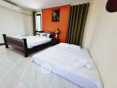 Spacious bedroom with two beds and modern decor, ideal for comfort and relaxation.