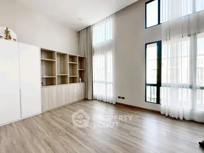 Spacious modern living room with large windows and elegant wooden flooring.