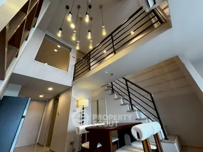 Modern duplex interior with stylish lighting and elegant staircase, perfect for contemporary living.