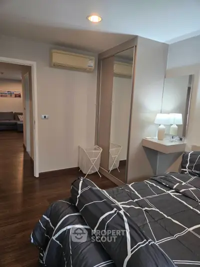 Modern bedroom with stylish decor and mirrored closet doors
