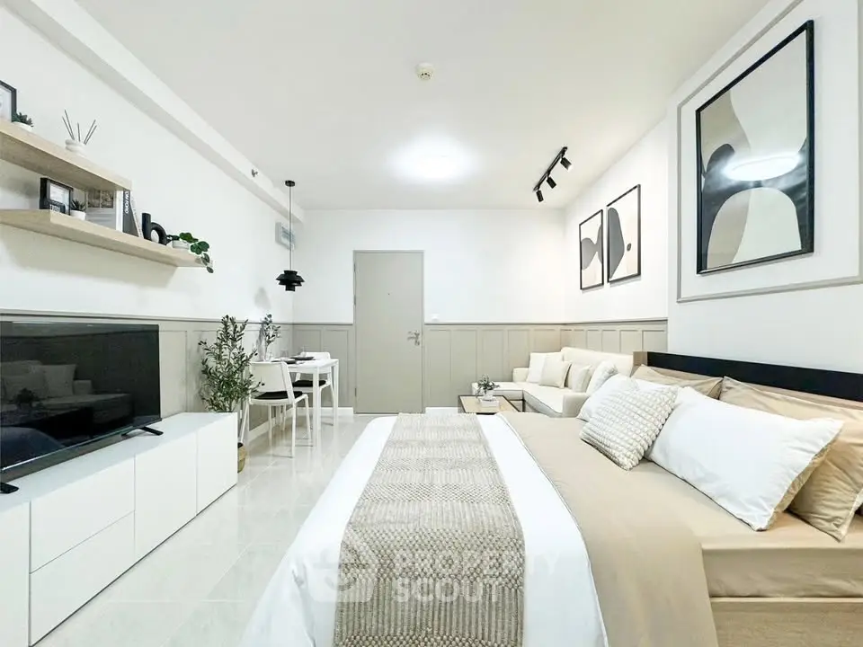 Modern studio apartment with stylish decor and open layout, featuring a cozy bed, sleek furniture, and contemporary art.