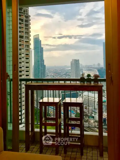Stunning cityscape view from a cozy balcony with seating area, perfect for relaxation.
