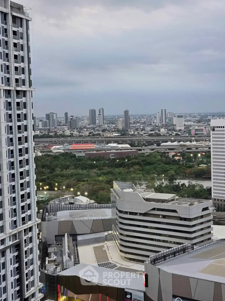 Stunning cityscape view from a high-rise building showcasing urban architecture and lush greenery.