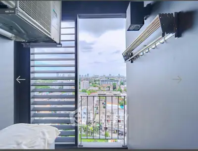 Stunning city view from a modern balcony with laundry rack and air conditioning unit.