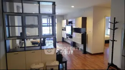 Spacious modern living room with wooden flooring and stylish decor in a contemporary apartment.