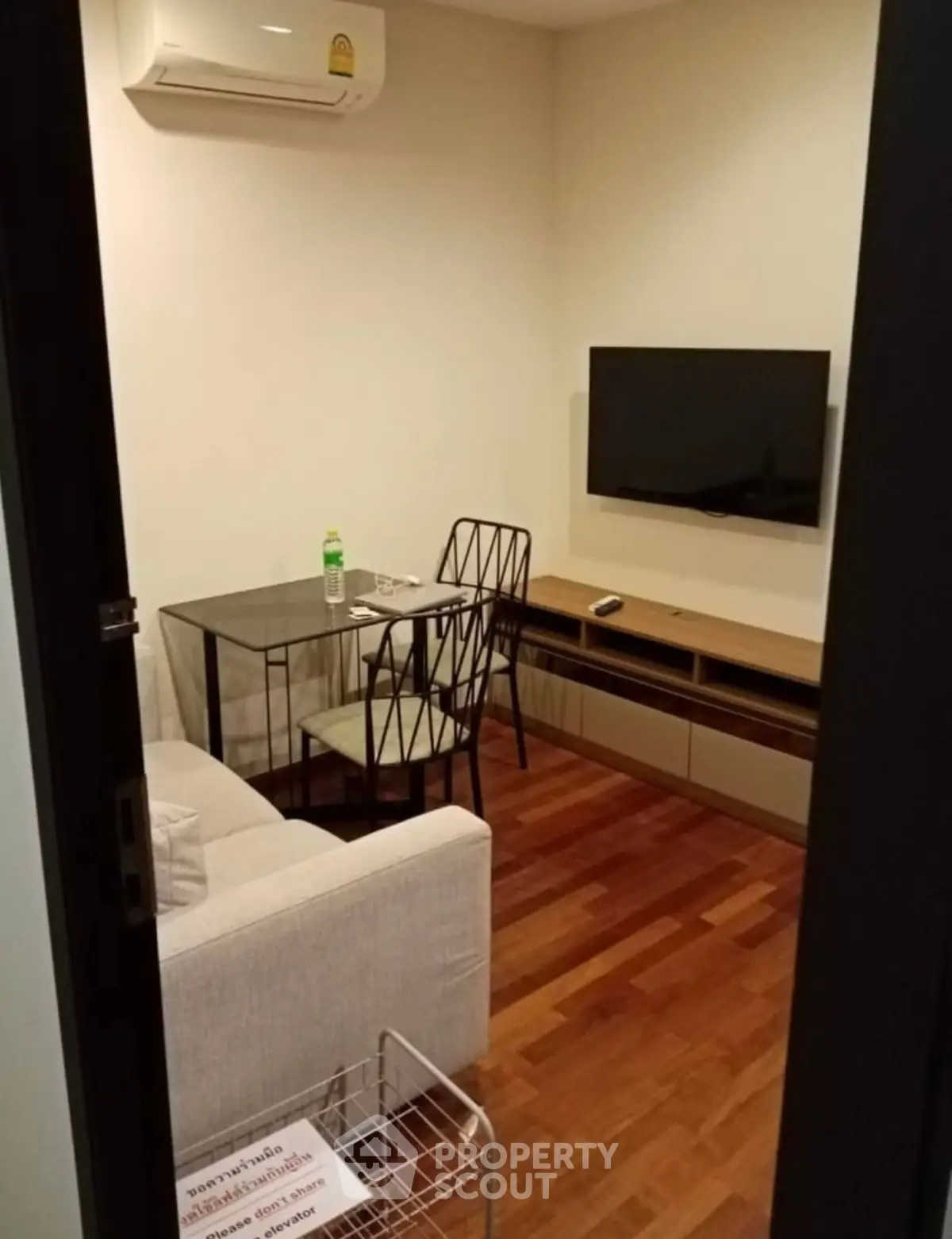 Cozy living room with modern furniture and wall-mounted TV, perfect for relaxation.