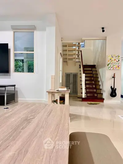 Spacious living room with modern decor and staircase in a stylish home