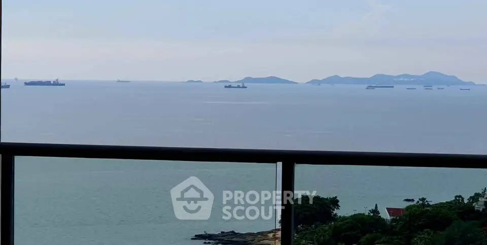 Stunning ocean view from a high-rise balcony overlooking distant islands and ships.