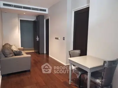 Modern apartment interior with hardwood floors, cozy sofa, and dining area, perfect for urban living.