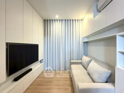 Modern living room with sleek white cabinetry and cozy gray sofa