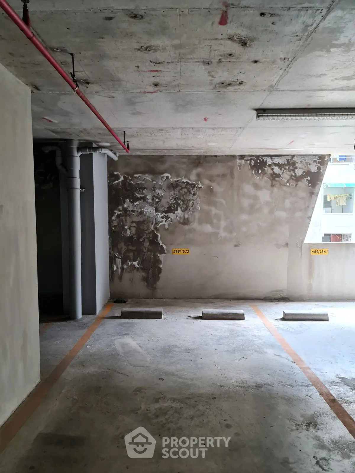 Spacious parking area in modern residential building with concrete finish.