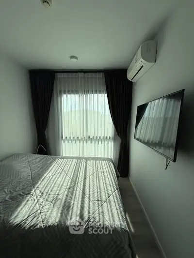Cozy bedroom with modern air conditioning and large window for natural light.