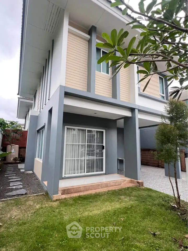 Modern two-story house with landscaped garden and stylish exterior design.