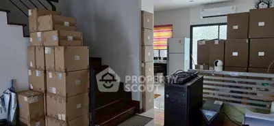 Spacious interior with stacked boxes, modern staircase, and air conditioning unit, ideal for storage or moving.