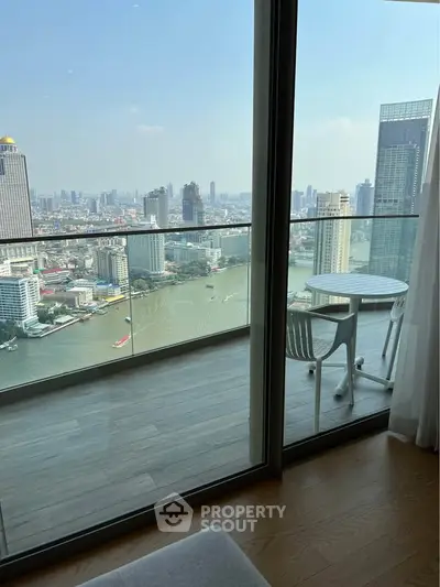 Stunning high-rise balcony with panoramic city and river views, perfect for relaxation.