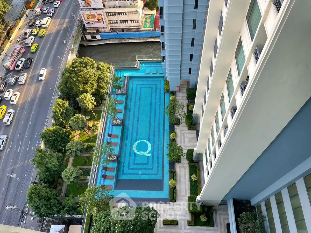 Stunning aerial view of luxury apartment building with inviting rooftop pool and cityscape.
