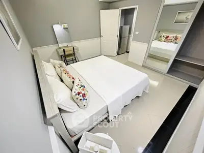 Charming bedroom with modern decor and mirrored closet in a cozy apartment.