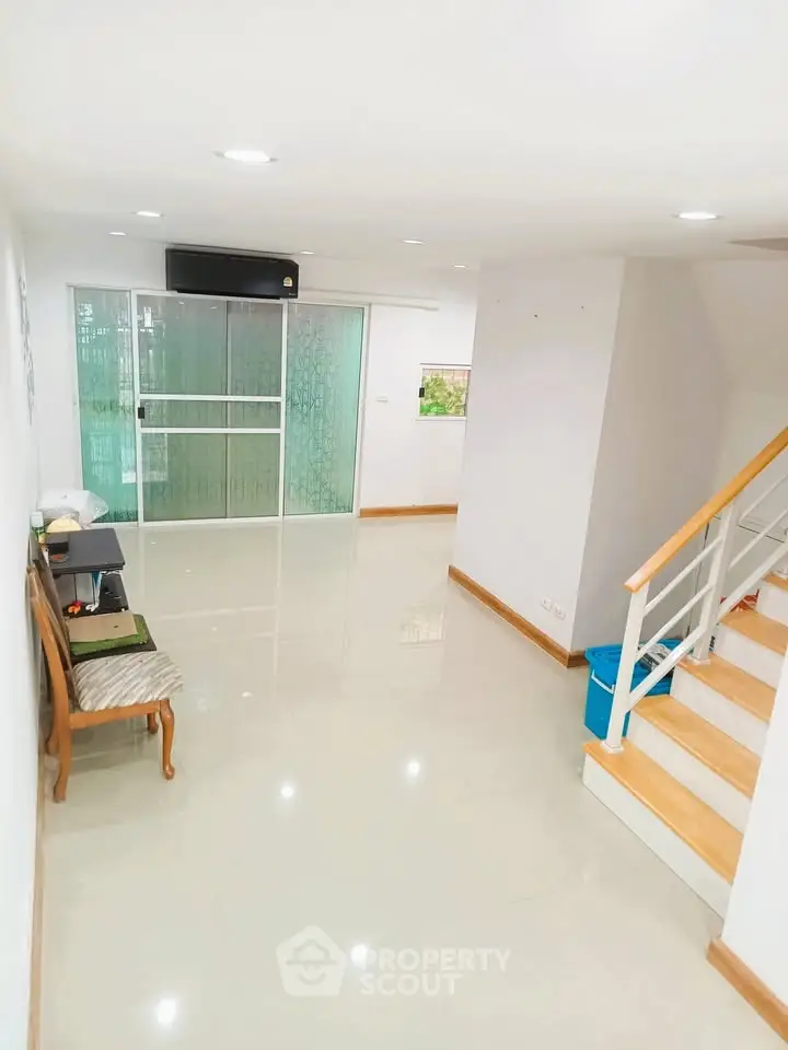 Spacious living room with modern staircase and glass sliding doors