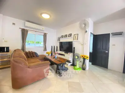 Spacious living room with modern decor and natural light, featuring a cozy brown sofa and stylish wooden coffee table.