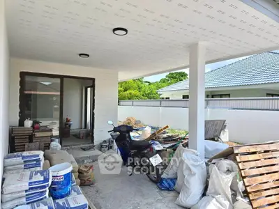 Spacious under-construction patio with building materials and motorbike, ideal for customization.