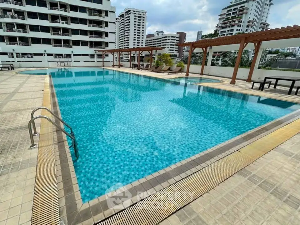 Luxurious rooftop pool with city views in modern residential complex.
