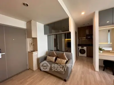 Modern living room with cozy sofa and integrated kitchen appliances in stylish apartment.