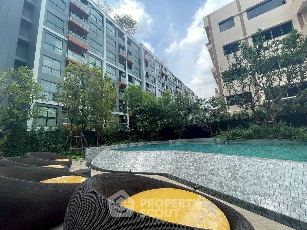 Modern apartment complex with pool and lush greenery, perfect for urban living.