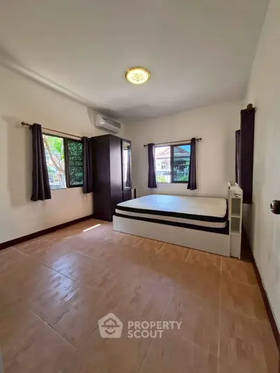 Spacious bedroom with natural light and modern furnishings