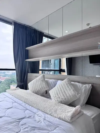 Luxurious bedroom with large windows offering stunning city views and elegant decor.