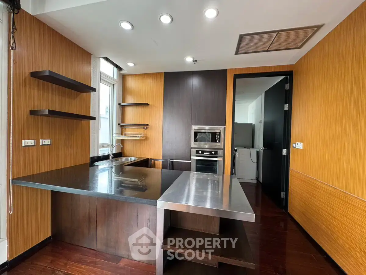 Modern kitchen with sleek design, featuring built-in oven and stylish countertops.