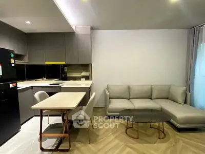 Modern open-layout kitchen and living room with sleek furniture and neutral tones.
