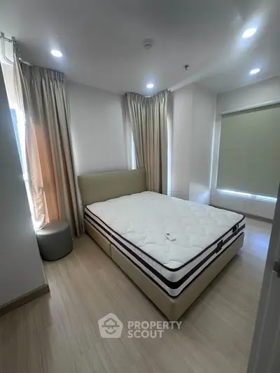 Modern bedroom with natural light and elegant curtains in a cozy apartment.