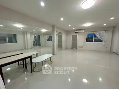 Spacious modern living room with large mirrors and elegant tables, perfect for entertaining.
