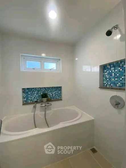 Modern bathroom with elegant bathtub and stylish blue mosaic tiles.